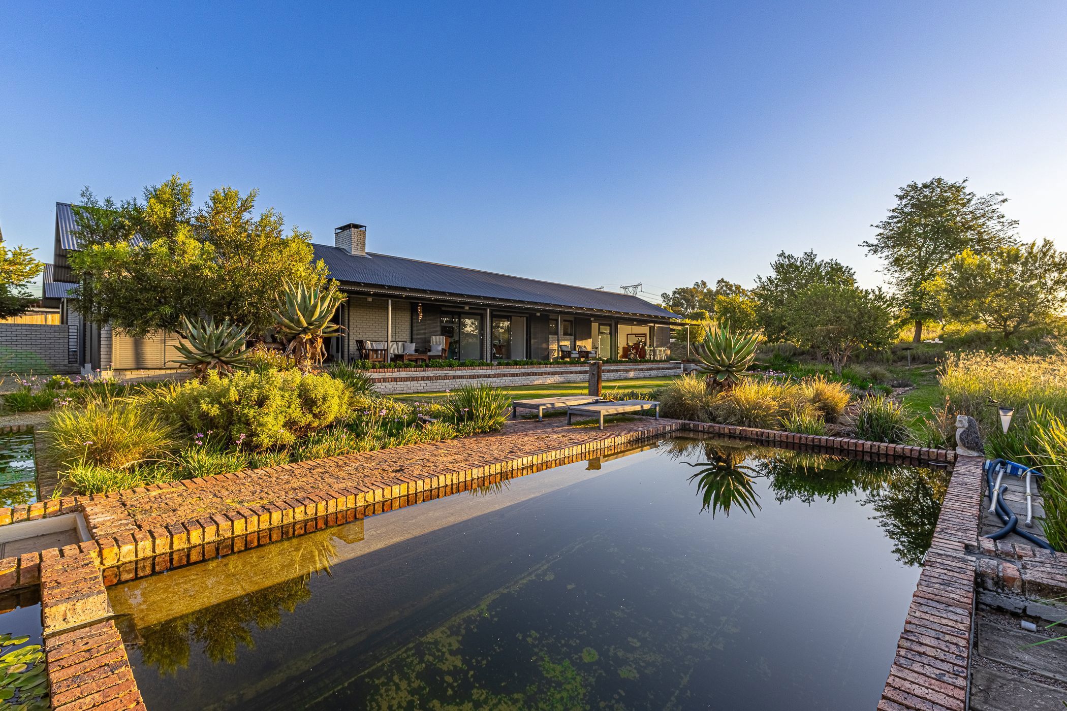 Marketed by Pam Golding Properties at R11.9 million, this spacious family home is set on a 4544sqm stand in Monaghan Farm and offers five bedrooms and five bathrooms. Designed with a blend of open-plan living areas, double-volume spaces and private retreats, it is ideal for seamless indoor-outdoor living. The courtyard includes a luxurious en-suite guest flatlet, ideal as a studio, granny cottage or work-from-home office, while additional features include four oversized garages, staff accommodation, a storeroom, an underground water tank, JoJo tanks and solar power. 