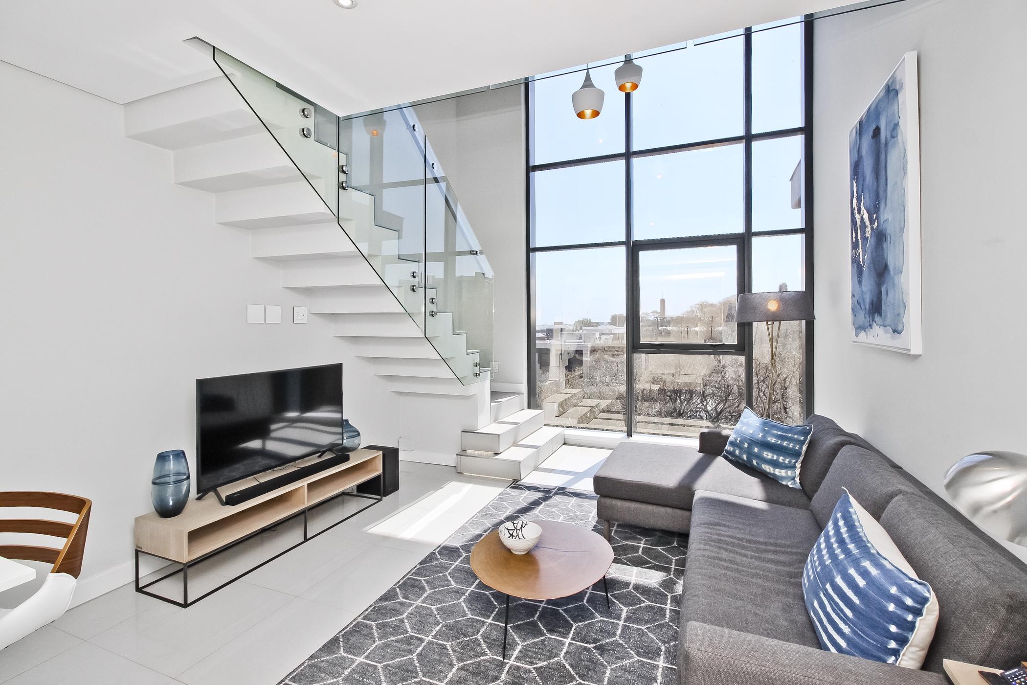 This sophisticated, one-bedroom loft apartment in Rosebank, Johannesburg, includes two garages and off-grid, alternative power solutions. The complex includes a rooftop swimming pool, state-of-the-art gym and concierge services. Priced at R2.2 million through Pam Golding Properties, the apartment features an open-plan kitchen, mezzanine bedroom, and offers exceptional skyline views. 