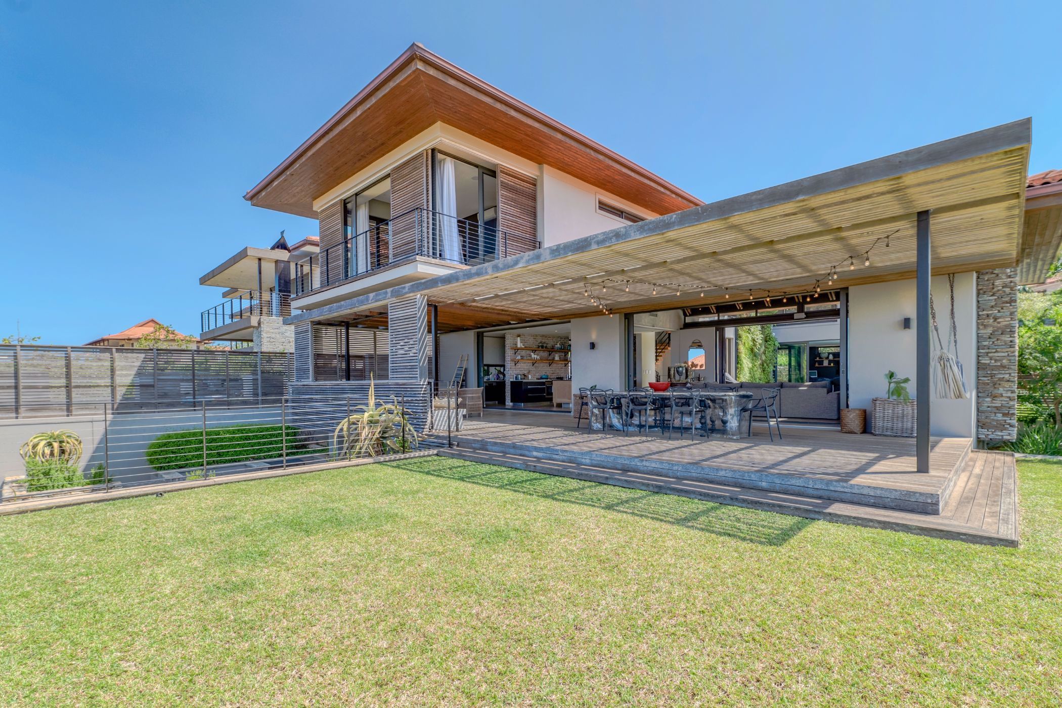 Situated in secure Izinga Estate in uMhlanga, KwaZulu-Natal, this modern four-bedroom, energy efficient property includes water tanks, a water purification system and an Inverter system housed in separate rooms, plus a rainwater harvesting system. Designed with concrete, wood, light and open spaces blending in harmony, the home includes a boma, three covered patio areas, study nook, TV lounge, swimming pool, landscaped garden, double automated garage and ample onsite parking, among other features. It is priced at R13.99 million through Pam Golding Properties. Situated in secure Izinga Estate in uMhlanga, KwaZulu-Natal, this modern four-bedroom, energy efficient property includes water tanks, a water purification system and an Inverter system housed in separate rooms, plus a rainwater harvesting system. Designed with concrete, wood, light and open spaces blending in harmony, the home includes a boma, three covered patio areas, study nook, TV lounge, swimming pool, landscaped garden, double automated garage and ample onsite parking, among other features. It is priced at R13.99 million through Pam Golding Properties.