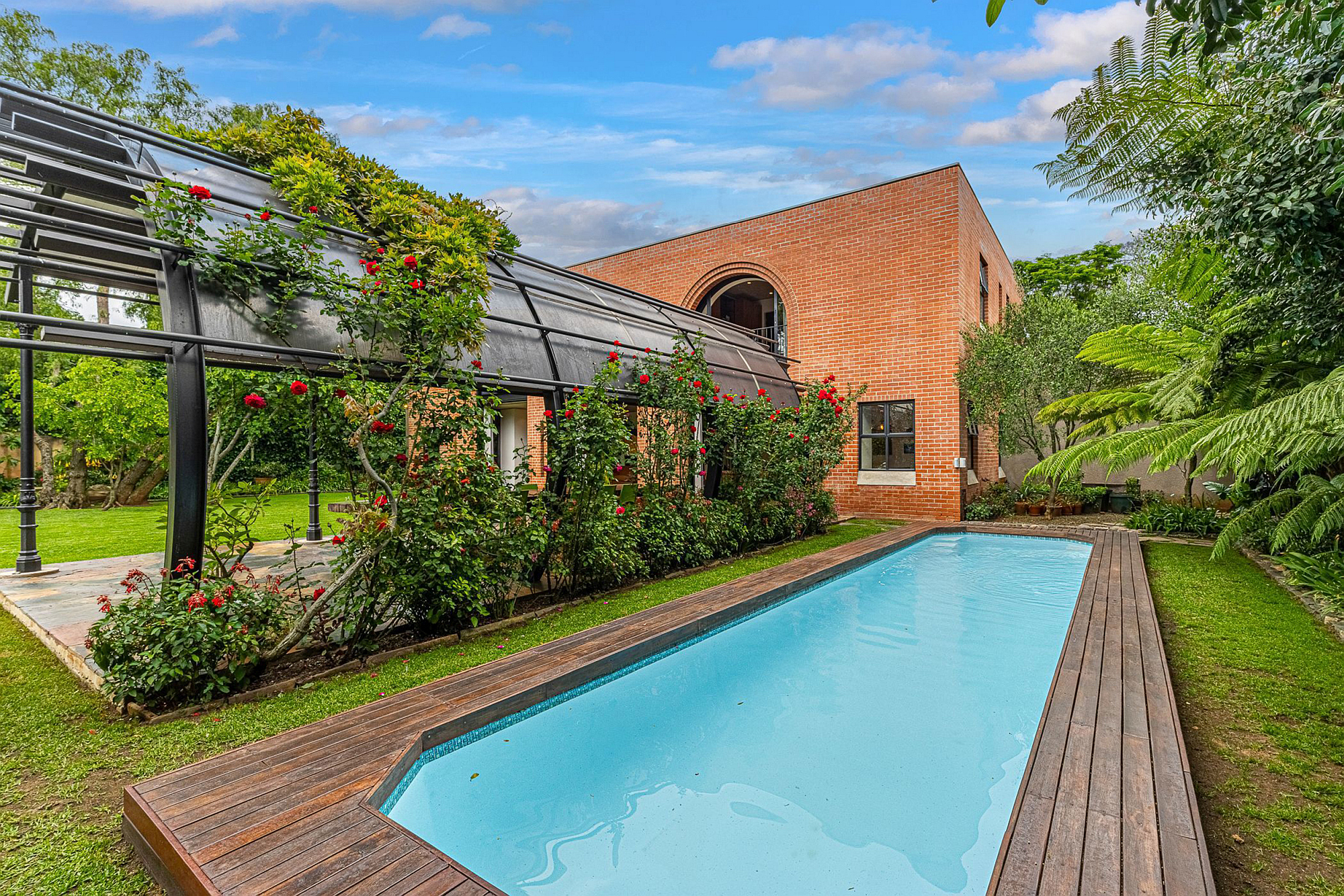 Westcliff R16.8m for sale: Marketed at R16.8 million by Pam Golding Properties, this distinctive five-bedroom (all en-suite) home in Westcliff merges with the surrounding idyllic gardens and the 40 different species of mature trees. A vast arched pergola is ideal for hosting garden parties and stands as an exceptional sculpture in its own right. Gleaming Eucalyptus wood features through the home.